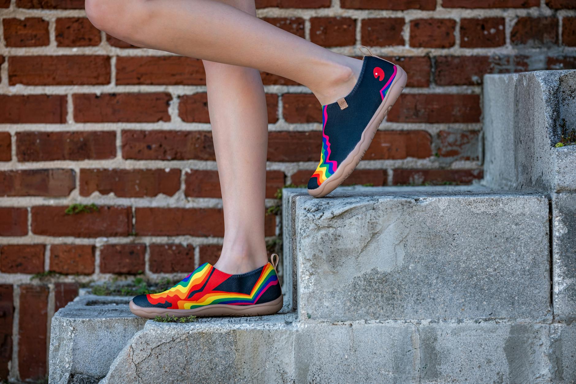 a woman in colorful shoes standing on some steps