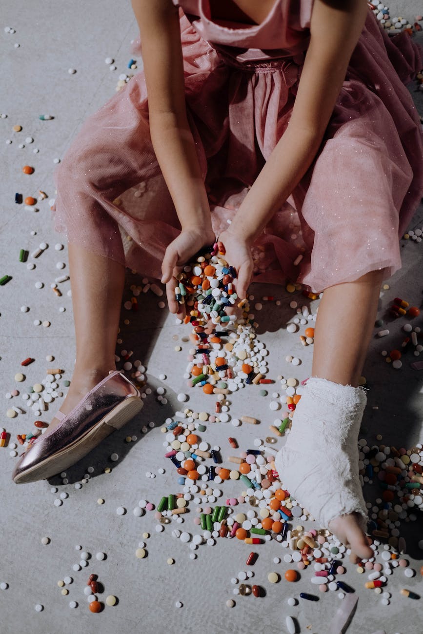 a girl in a pink dress with orthopedic cast sitting on the floor